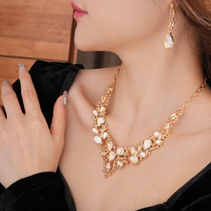 Close-up of elegant gold drop necklace and earring set worn on model neck