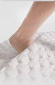 Macro shot of white memory foam bath mat with embossed bubble texture and fast drying fibers