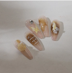 Detail of marble pattern nail art featuring yellow butterfly and embossed white roses