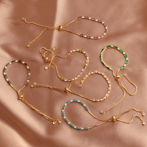 Adjustable gold bracelets featuring colorful rectangular zircons on beige satin fabric
