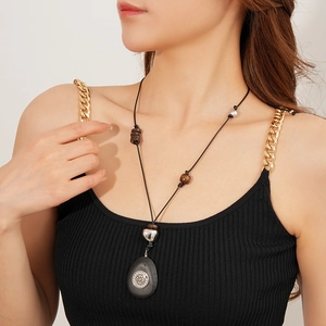 Sautoir ethnique avec pendentif ovale en bois et pierre porté par un mannequin
