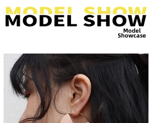 Model wearing geometric gold hoop earrings with wood texture accents in a natural side profile