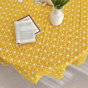 Detail of yellow cotton linen tablecloth with white geometric triangles and fabric texture