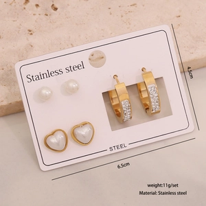 Detailed macro view of 3-piece gold stainless steel earring set with heart and pearl studs