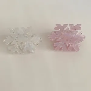 Elegant snowflake hair claws in white and pink acetate with sparkling rhinestones