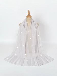 Close-up of light gray chiffon shawl with sparkling rhinestones on a mannequin