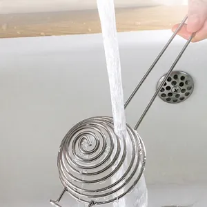 Stainless steel egg white separator and spiral whisk being rinsed under water