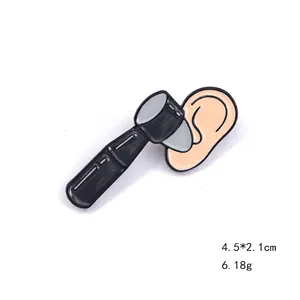 Detail view of medical otoscope enamel pin badge, 4.5x2.1cm black and beige zinc alloy brooch