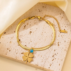 Pulsera de doble capa dorada con trébol y ojo turco sobre piedra y seda fina