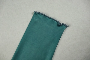 Detailed macro view of the dark green dress showing ribbed texture and lettuce hem edge