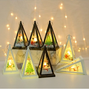 Close-up of LED Christmas lanterns with Santa and reindeer motifs on marble blocks