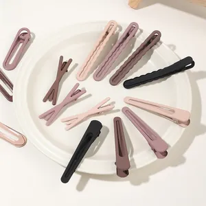 Detailed close-up of matte brown and pastel hair clips set arranged in a white ceramic dish