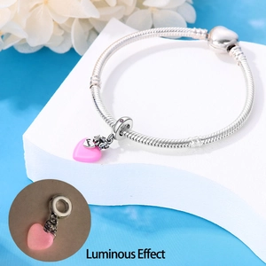 Luminous pink heart charm with Love engraving on a silver snake chain bracelet