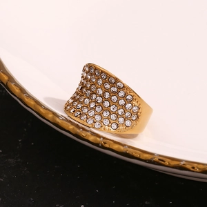 Détail macro d'une bague large plaquée or 18 carats ornée de cristaux scintillants pavés