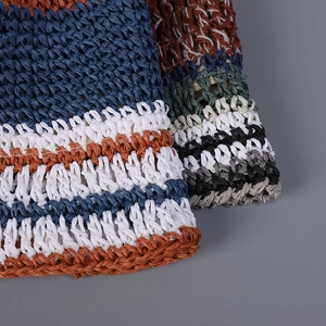 Close-up detail of the intricate woven texture on a colorful striped straw bucket hat.