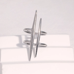 Macro detail of a punk style silver spike ring on a minimalist white geometric pedestal