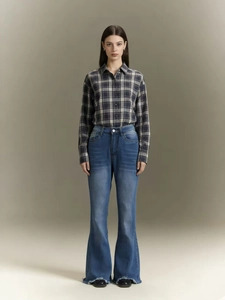 Detail of high waisted flare jeans with distressed hem and vintage blue wash finish