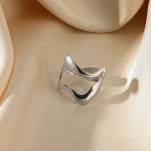 Close-up of irregular wave design open ring on elegant champagne gold silk fabric