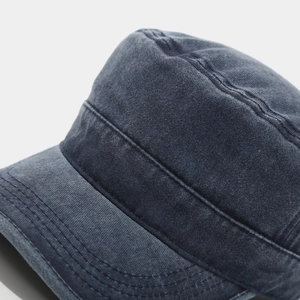 Detail of washed denim texture and fine stitching on a vintage flat top army cap