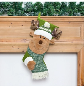 Detail of knitted green Christmas stocking featuring a 3D plush reindeer with reindeer antlers