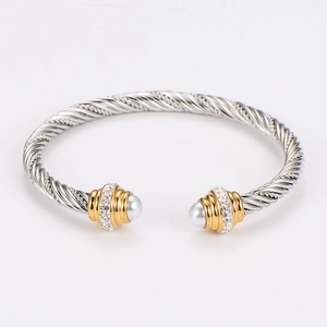 Macro shot of silver cable bangle with gold accents, white pearls and sparkling crystals