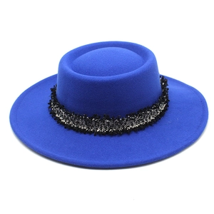 Detalle de sombrero de lana azul real con ribete de cinta de flecos en tweed bicolor
