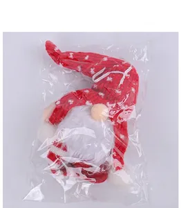 Détail d'un gnome de Noël avec bonnet en tricot rouge dans son emballage en plastique