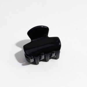 Top view of a small glossy black resin hair claw clip with smooth polished finish