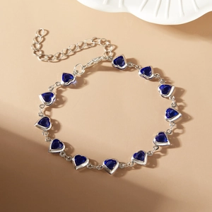 Detail of blue heart-shaped gems linked on a silver chain with adjustable lobster clasp