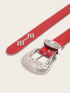 Close-up of red crocodile embossed leather belt with silver carved buckle and rivets
