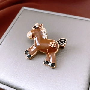 Close-up of vintage horse brooch with brown enamel inlay and white zircon accents