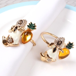 Golden rabbit napkin ring with white enamel and amber crystal on a white napkin