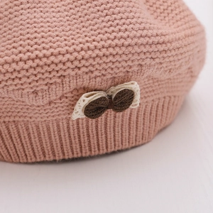 Sweet pink knit beret for girls with cozy bow and pompom detail for winter warmth