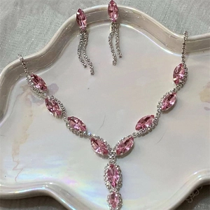 Detail showing pink marquise-cut gems on silver necklace and matching earrings