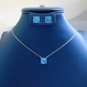 Detail of cushion-cut blue gem jewelry set with silver necklace and stud earrings