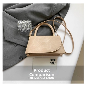 Close-up of beige trapezoid handbag showing smooth texture and metallic strap hardware