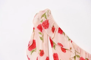 Detailed macro view of chiffon fabric with red floral print and ruffle edge finish