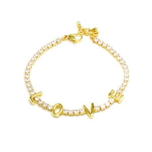 Detail of gold tennis bracelet with LOVE lettering and shimmering pave-set cubic zirconia