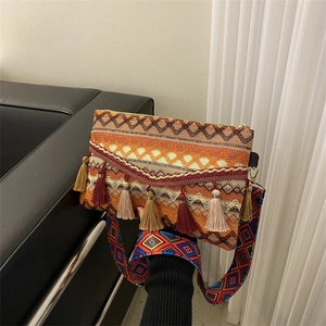 Detail of bohemian woven handbag with colorful tassels and ethnic embroidered strap