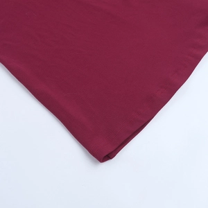 Macro detail of wine red evening dress showing double-needle stitching on knitted fabric