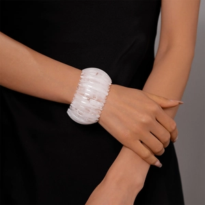 Gros plan détaillé d'un bracelet de perles en acrylique blanc sur le poignet