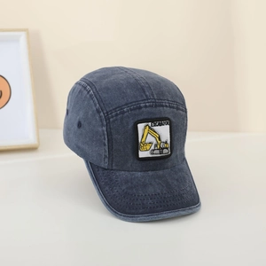 Detail of blue-gray washed denim camper hat featuring a yellow excavator patch embroidery