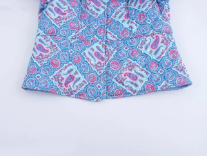 Detailed view of women's padded jacket featuring blue and pink paisley print pattern