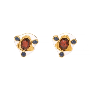 Detail view of vintage gold earrings with red oval gems and blue zircon stones