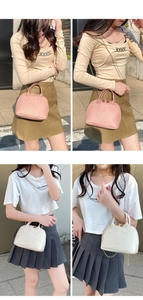 Close-up of shell-shaped crossbody bags featuring gold chain straps and leather handles