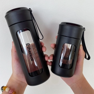 Detail of matte black glass water bottles with carry strap and Ethereal window design