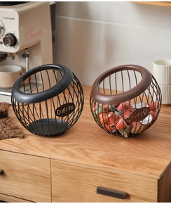Detail of wire mesh coffee pod holders in black and bronze finishes for kitchen storage