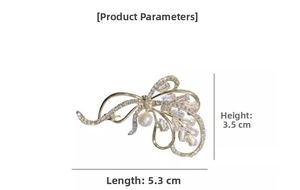 Detailed view of a gold bow brooch with pearl and crystal, size 5.3cm by 3.5cm