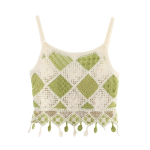 Detail of crochet knit crop top featuring green diamond pattern and fringe tassels