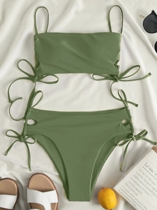 Detail of olive green bikini set with side drawstring and high waist on summer beach props